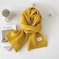 Vibrant yellow knit scarf with emo patch and ribbed edges on an aesthetic white background - Yellow