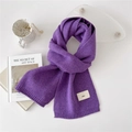 Soft purple knitted scarf with emo logo tag and ribbed edges on white desk with accessories - Purple