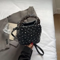 Quilted black bucket bag with silver rhinestones and adjustable strap in a modern setting - Black