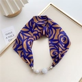 Detail of silk scarf necklace featuring blue abstract floral patterns and rhinestone charms - Blue and Brown Floral