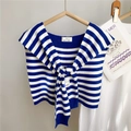 Détail d'un châle en tricot à rayures bleues et blanches avec nœud décoratif sur un cintre - Rayures Larges Bleu