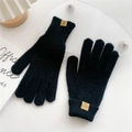 Detail von schwarzen Strickhandschuhen mit Lederetikett und weicher Acrylstoff-Textur - Schwarz