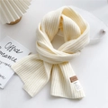 Dettaglio di sciarpa in maglia crema con etichetta logo in pelle e istruzioni lavaggio - crema