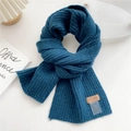 Detail of navy rib-knit scarf featuring leather brand tag and care instructions label - Lake Blue