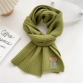 Macro detail of grass green ribbed knit scarf featuring a brown leather brand tag - Yellow-Green