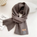 Detail of coffee-colored ribbed knit scarf with a leather brand tag and care label - Light Coffee