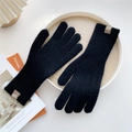 Close-up of black knitted gloves with premium brown leather label and warm ribbed cuffs - One Size / Black