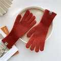Close-up of rust red knitted gloves with ribbed cuffs and leather brand label detail - One Size / Orange