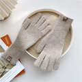 Close-up of oatmeal knitted gloves with leather brand label on a wooden tray - One Size / Coffee