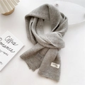 Dettaglio della sciarpa in maglia grigia con trama morbida ed etichetta moda artigianale - 22x180cm / Grigio chiaro