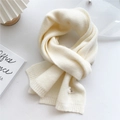 Detail of soft cream knit scarf showing fine ribbed texture and decorative woven label - 22x180cm / Creamy White