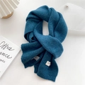 Detailed close-up of dark blue knit scarf texture with handmade label on white desk - 22x180cm / Lake Blue