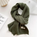 Detail of dark green knitted scarf with handmade label on a clean white background - 22x180cm / Moss Green