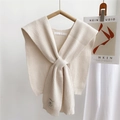 Dettaglio scialle in maglia color crema con trama a coste e nodo incrociato sul davanti - 35*90cm / crema