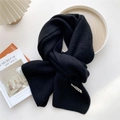 Detail of black rib-knit scarf with minimalist GRACE label on a white background - Black