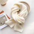 Close-up of off-white chunky knit scarf with ribbed texture and GRACE label detail - Cream