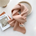 Detailed knit texture of pink scarf with GRACE label on white tray with decor - Pink