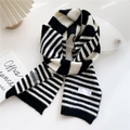 Classic black and white striped knitted scarf with soft plush texture and woven label detail - Black