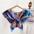 Elegante foulard in seta blu e arancione annodato a fiocco su una gruccia - Motivo Medusa/Spazio