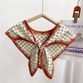 Beige silk neck scarf with black D-print pattern and orange trim on a wooden hanger - Letter D Monogram