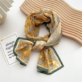 Long yellow silk scarf with leaf patterns and green borders in an elegant knotted fold - 20 Chiffon Leaf Green Border