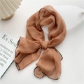 Brown chiffon scarf with fine black stitched edges in a stylish lifestyle arrangement - Caramel color