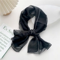 Elegant black chiffon scarf with white wave embroidery tied in a bow on a white tray - Black