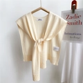 Cream knit shawl shoulder wrap with premium ribbed edges and elegant brand label - Beige