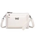 White faux leather crossbody bag with multiple zippers and a metal bow accent - White
