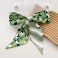 Green silk-like ribbon scarf featuring white floral patterns on a wooden tray - Cotton Green (7X)