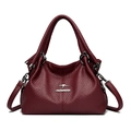 Macro detail of bordeaux red lychee leather texture and golden kangaroo logo hardware - Red