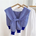 Detail eines blau-weiß gestreiften Strickschals mit Knoten auf weißem T-Shirt - Blau Gestreift / 40x95cm
