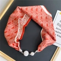 Close-up of geometric silk scarf with magnetic silver buckle and rhinestone spheres - Orange & White Geometric Texture (12M Crease Lines Orange-Red)