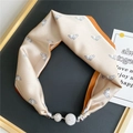 Detail of silk scarf necklace with horse pattern and sparkling rhinestone magnetic clasp - Champagne Gold Horse Head Print (15M Small Horse Head Orange Border)