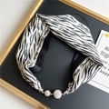 Detail of zebra print silk scarf with luxury silver rhinestone magnetic ball buckle - Black White Zebra