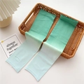 Detail of gradient green ice silk cooling sleeves with thumb holes in a basket - One Size / Gradient Green