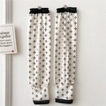 Close-up of cream sun protection sleeves with black cross-star pattern and elastic cuffs - Black and White Cross Snowflake Print