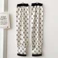 Detailed close-up of white sun protection sleeves with black geometric letter patterns - Letter G Black and White Monogram