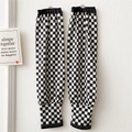 Close-up of black and white checkerboard sun protection sleeves with elastic cuffs - Small Black and White Checkerboard