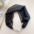 Close-up of silk necktie necklace with gold clover patterns and sparkling crystal spheres - Camel Black Clover Pattern