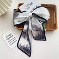 Pleated skinny scarf with black and white landscape print displayed in a woven basket - 1 Pleated Reed (Ink Black & White)