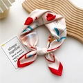 Foulard quadrato in seta rosa con stampe floreali rosse annodato su un display - Tulipano Rosso