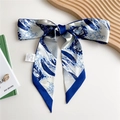 Blue and white wave print silk-feeling twilly scarf tied in a bow on a white desk - 125cmx7cm / Sea Wave