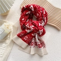 Knitted winter scarf with red and white snowflake patterns in a cozy display - Red