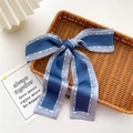 Nastro di seta blu a forma di fiocco con stampe alla moda in un cesto di vimini - Contrasto Blu Marino