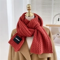 Detailed knit texture and brand label on a thick caramel winter scarf with braid pattern - Dark Red