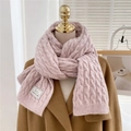 Pink cable-knit long scarf with branded label styled on a wool coat for winter fashion - Purple