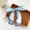 Light blue and white silk ribbon scarf with Fashion Girl print tied in a bow - Light Blue Contrast