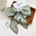 Lichtgroene geplooide sjaal met elegante print in een vintage gevlochten mand - Geplooid Groen met Letterrand
