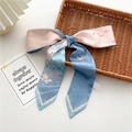 Narrow silk ribbon scarf with floral koi fish print tied in a bow on a woven basket - 7x130cm / Silver Lotus Leaf Koi